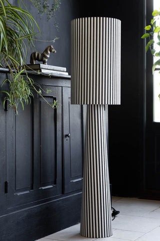 Lifestyle image of the Black & White Stripe Floor Lamp with a black cabinet and zebra ornament