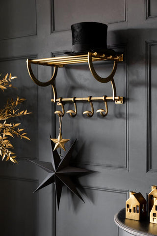 Lifestyle image of the Antique Gold Luggage Rack With Coat Hooks