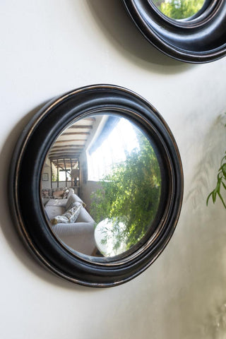Lifestyle image of the Antique Black Round Framed Medium Convex wall Mirror.