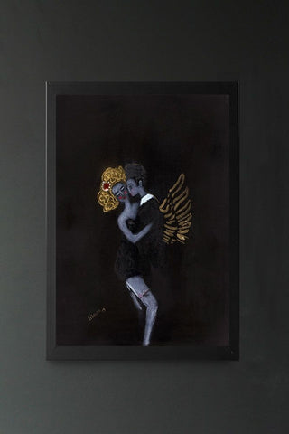A moody art print of a couple dressed in black, the woman with gold hair and the man with gold angel wings, in a black frame hung on a grey wall.
