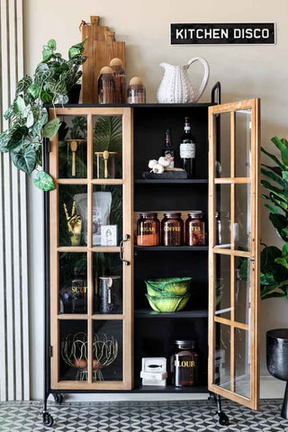 Lifestyle image of the Industrial Style Wooden Display Cabinet On Wheels with one door closed