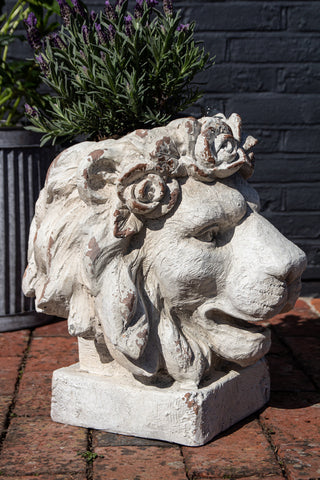 Side angle lifestyle image of the Large Rustic Stone Effect Lion Head Planter