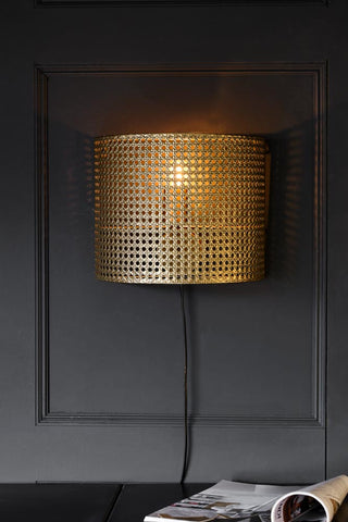 Lifestyle image of the Gold Metal Wicker Effect Plug In Wall Light
