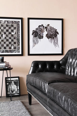 Lifestyle image of Black Leather Chesterfield 3 Seater Sofa with painting hung on wall and black side table on grey rug