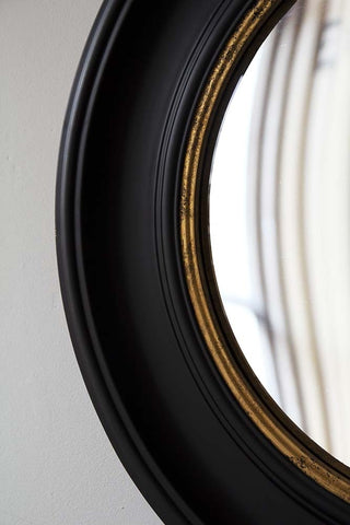 detail image of mirror edge of Black Convex Mirror With Aged Gold Detail on pale wall background
