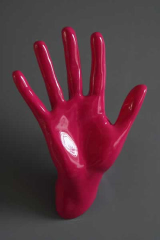 lifestyle image of waving hand wall art & coat hook hot pink on grey wall background