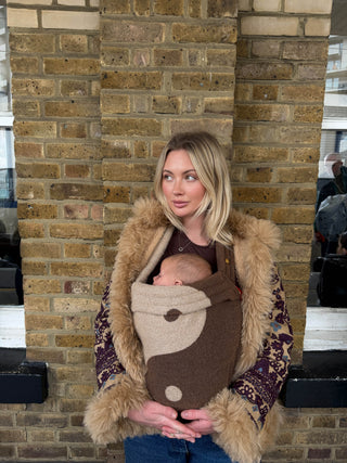Grace Chadd stood against a brick wall with her baby. 