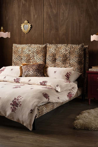 A leopard print bed styled with beautiful floral bed linen