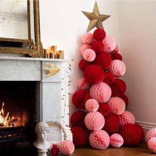 a red and pink honeycomb Christmas tree with a gold star topper