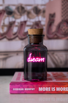 A neon light in a bottle that says 