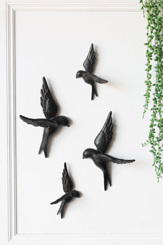 A set of 4 black birds wall decor on a white wall. 