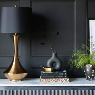 image of black and gold table lamp styled on a marble console table