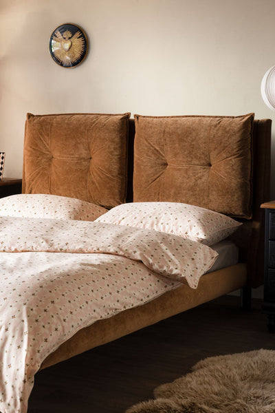 Stripe Bed decorated with pink bedding, cushions and throws.