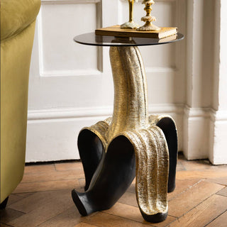 The Small Black Star Side Table styled in a living room space with three candlesticks on top with melted wax.