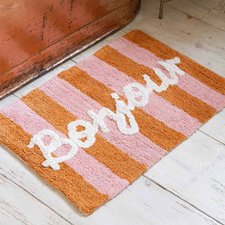 Lifestyle image of Bonjour bathmat styled on a wooden floor next to a copper bath. 