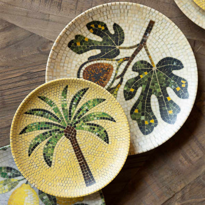 Various patterned mosaic plates styled together on a wooden surface.