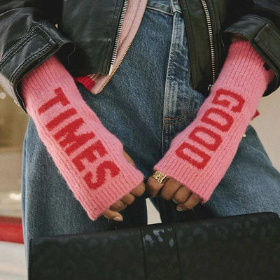 A model wearing some pink and red handwarmers with the text 'good times' written on them.