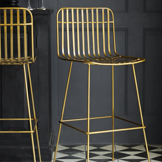 Two Midas Bar Stools displayed in a black panelled room with a monochrome geometric patterned floor.