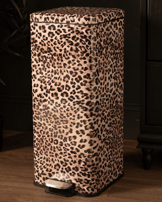 A tall rectangular pedal pin with a leopard print pattern in beige, brown, and black, featuring a silver and black foot pedal on a wooden floor.
