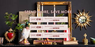 Decorative items on a shelf with a promotional sign for saving money, against a dark wall.