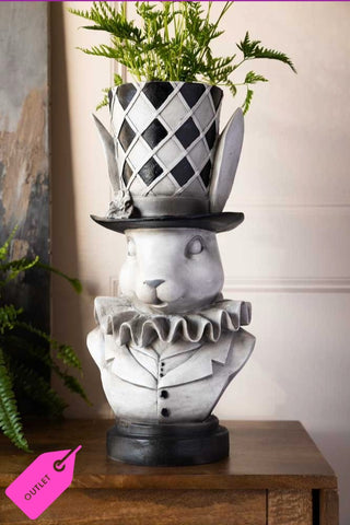 Lifestyle image of the Alice In Wonderland 'Rabbit' Bust Plant Holder styled on a wooden side board 