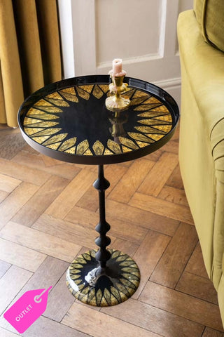 Lifestyle image of the Black & Gold Art Deco Inspired Side Table on a wooden floor next to a sofa