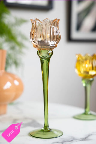 The Vintage-Style Orange Glass Flower Candle Holder styled on a white table.