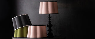 Green, black and cream scalloped lampshades stacked next to each other.