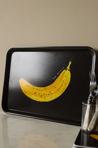 Lifestyle image of the Top Banana Tray, styled with cutlery, glassware and placemats on a white work surface. 