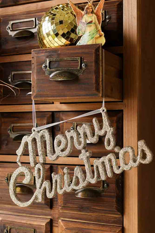 Lifestyle image of the Champagne Glitter Merry Christmas Decoration Sign on drawers
