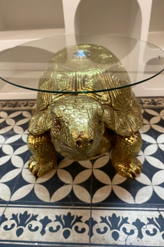 Front view of the Gold Tortoise Side Table on a patterned floor.