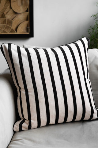The Monochrome Striped Velvet Cushion Cover reverse side shown on a white chair.