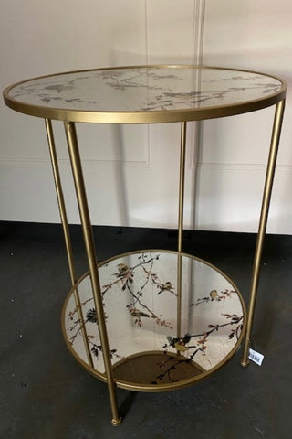 Image of the Gold Beautiful Birds Mirror Side Table showing on a black floor.