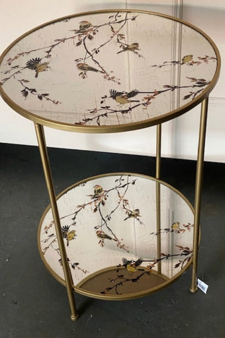 Image of the Gold Beautiful Birds Mirror Side Table on a dark floor.
