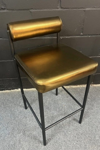 Image of the Burnished Gold Roll Back Bar Stool against a dark background.