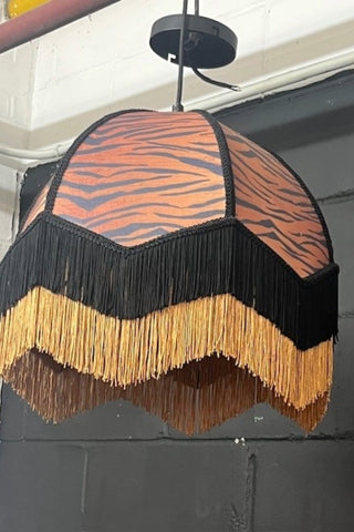 The fringed tiger print lampshade hanging.