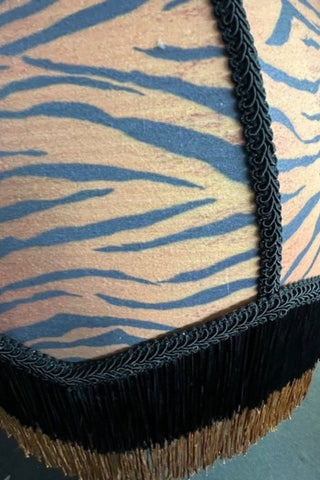Close up image of the fringed tiger print lampshade.