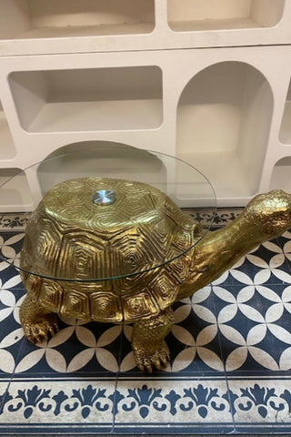 Side view of the Gold Tortoise Side Table sitting on a geometric floor.
