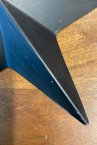 Detail of a star from the Set Of 3 Black Metal Stars on a wooden background
