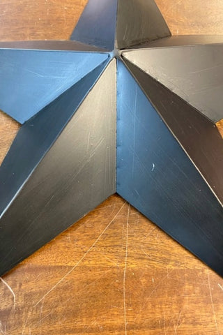 Close up of Image of a star from the Set Of 3 Black Metal Stars on a wooden background