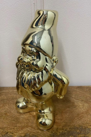 The Gold Gnome Single Stem Vase / Candlestick Holder against a white wall on a wooden surface.