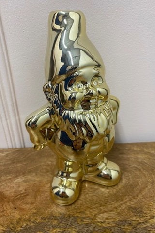 The Gold Gnome Single Stem Vase / Candlestick Holder against a white wall on a wooden surface.
