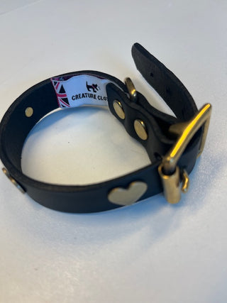Close up of Black Leather Dog Collar with Hearts on a white background.