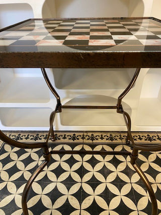 Side view of the  Bronze Effect Chess Side Table  on a monochrome floor.