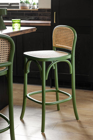 Two of the Chez Pitou Wood & Woven Cane Bar Stool in Green next to a kitchen island.
