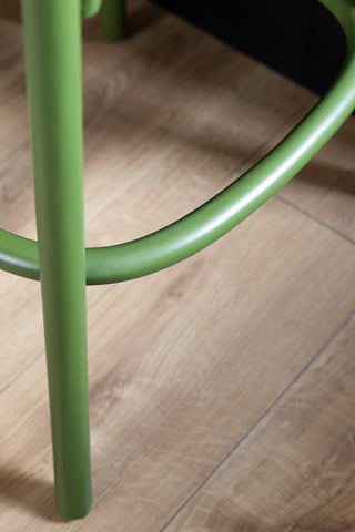 Close-up of the footrest on the Chez Pitou Wood & Woven Cane Bar Stool in Green.
