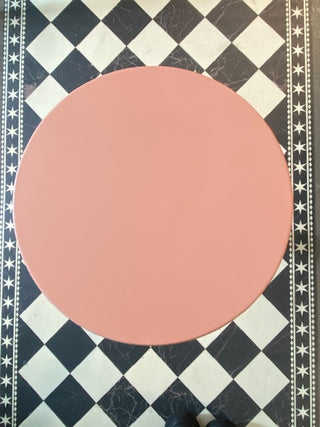 Birds eye view of The Wood Turned Pink Side Table on a black & white floor.