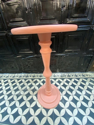 The Wood Turned Pink Side Table on a geometric floor