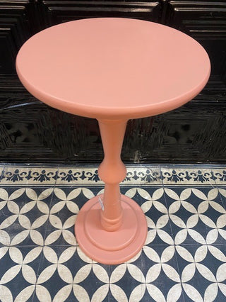 The Wood Turned Pink Side Table on a geometric floor