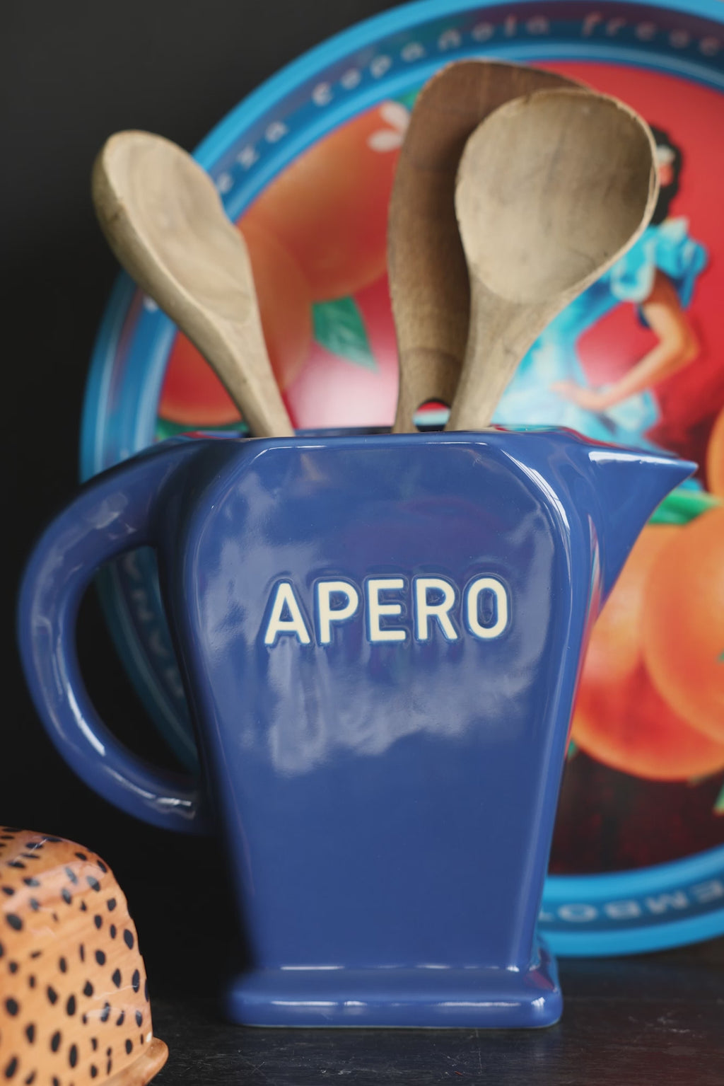 A wooden spoon being taken out of the Stylish Dark Blue Apero Water Jug.